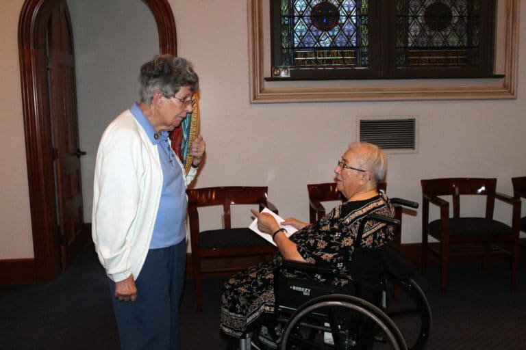 Sister Luisa Bickett talks to Sister Sara Marie Gomez prior to the 4 p.m. Mass on Dec. 11. The two sisters helped plan the special Mass.