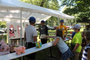 A young girl throws bean bags and tries to hit the circles in the Hog Wild game. The booth was staffed by Brescia University baseball players.