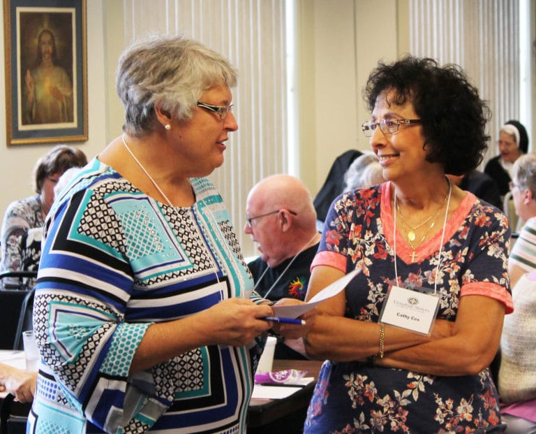 Associate Delores Turnage, left, of Owensboro, chats with Associate Cathy Cox, of Kansas City, Mo., during the time devoted to sharing with someone unknown to you.