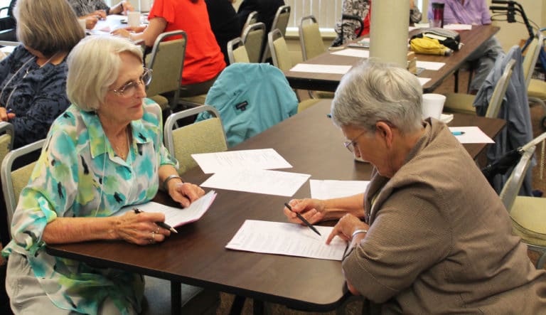 Associate Coreen Moore, left, of Clarkson, Ky., goes over her notes with Sister Mary Celine Weidenbenner.