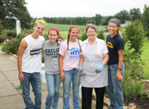 Sister Amelia Stenger, second from right, congregational leader for the Ursuline Sisters, poses with the teens who helped weed the gardens on campus.