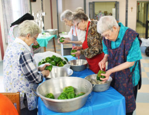 Where’s the peck of pickled peppers Peter Piper picked? Being cut up by this band of expert green pepper sisters. Around the table from right are Sisters Marie Montgomery, Clara Reid, Mary Gerald Payne, Michael Ann Monaghan (partially hidden) and Naomi Aull.