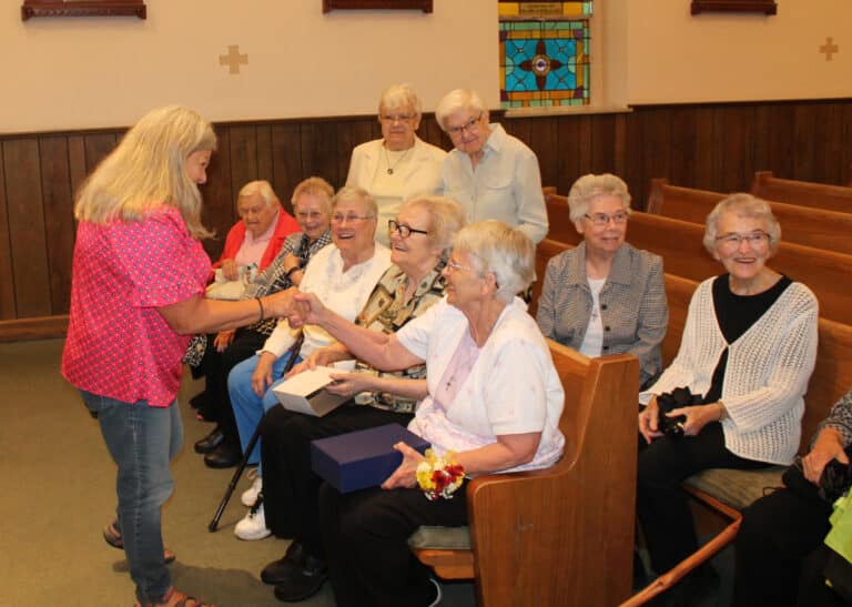 Ursuline Associate Debbie Lanham, left, a member of St. William Church, congratulates Sister Mary Celine after Mass.