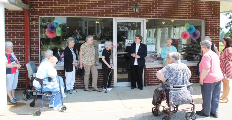 Sister Amelia Stenger, center, laughs with the Ursuline Sisters and staff after cutting the ribbon and pronouncing the Gift Shop open for business.