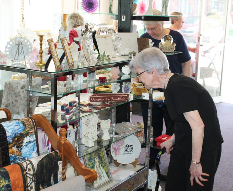 Sister Mary Diane Taylor looks over some patriotic items for sale, while at back, Sister Pat Lynch shops for some Saint Angela Merici merchandise.