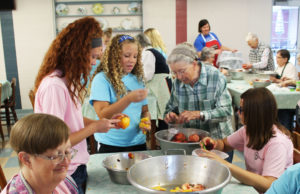 Taylor Pedley, in the blue shirt, from the Whitesville Y-DOSA chapter, reads the number she just pulled from the cup offered by Sister Grace Swift, right. Sister Grace was offering two jars of homemade jam to whichever girl pulled the winning numbers. Standing at left is Abby Carlson from Kansas, with Sister Rebecca White (bottom left) and Tatum Schumaker (Kansas) right.