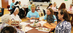 Sister Judith Osthoff, left, and Sister Emerentia Wiesner, second from left, play bingo with Maggie Foster, center, and Makenna Greenwell, both of Whitesville, as Debbie Dugger, right, activities coordinator, calls bingo numbers.