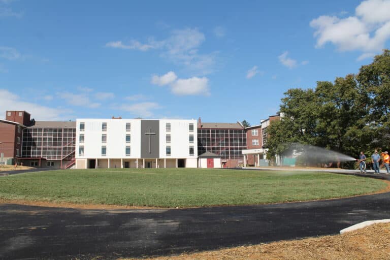 The view from the back of campus, as new asphalt encircles a sodded area where Paul Volk Hall once stood. To the left is Lourdes Hall, to the right Saint Ursula Hall and Saint Joseph Villa.