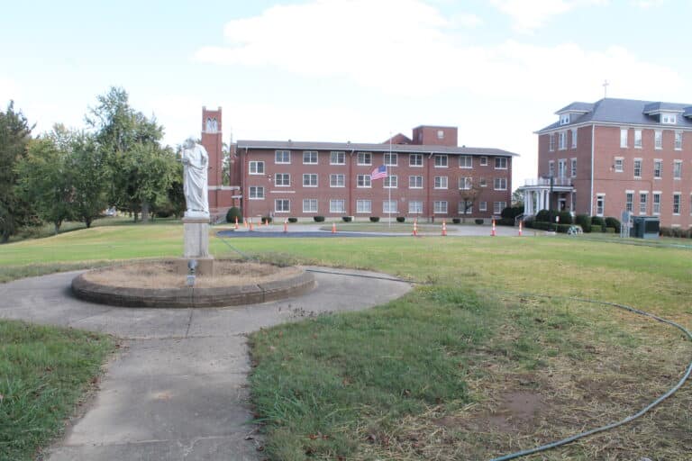 Grass on the front of campus is watered as the Saint Joseph statue that was formerly in front of the original Academy building now lines up with the bell tower for the Motherhouse Chapel. In the background are Lourdes Hall and Saint Angela Hall.