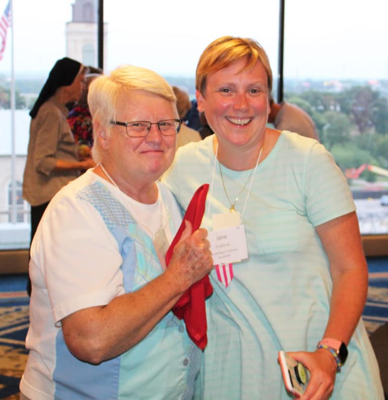 Ursuline Sister of Mount Saint Joseph Suzanne Sims, left, shares a smile with Jane Cruthirds, who teaches theology at Sacred Heart Academy in Louisville. Cruthirds was a member of the convocation planning committee.