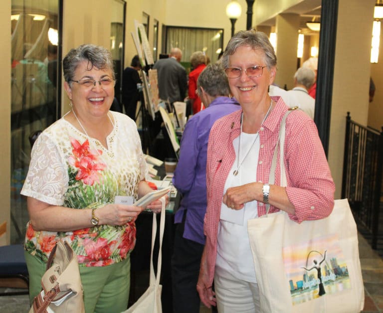 Ursuline Associate of Mount Saint Joseph Karen Siciliano, left, and Ursuline Sister Mary Ellen Backes, both of Springfield, Ill., share a laugh after visiting the display tables on July 26.