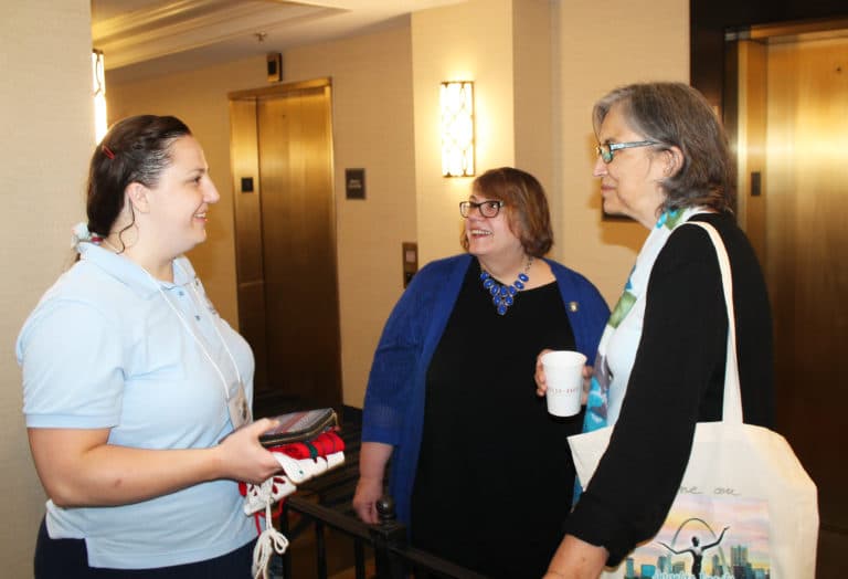 Ursuline Associates Renee Schultz, left, and Joanne Thompson, center, both of Kansas, chat with Ursuline Sister Larraine Lauter prior to the keynote speaker on July 26.