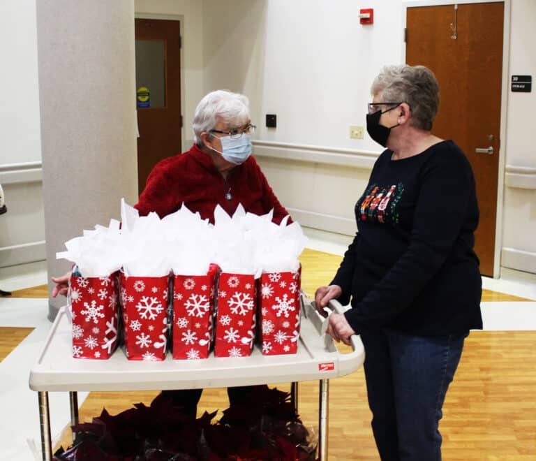 Sister Cecelia Joseph Olinger, left, talks with Associate Lois Bell before wheeling the cart full of goodies down the hall. Sister Cecelia Joseph hosts the Associates in the Guest House.