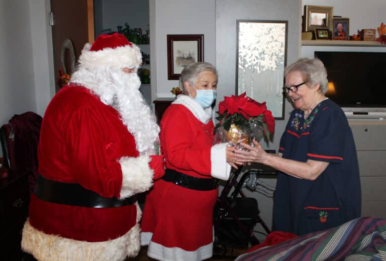 Sister Pat Rhoten is thrilled with her poinsettia gifted to her by the first couple of the North Pole.