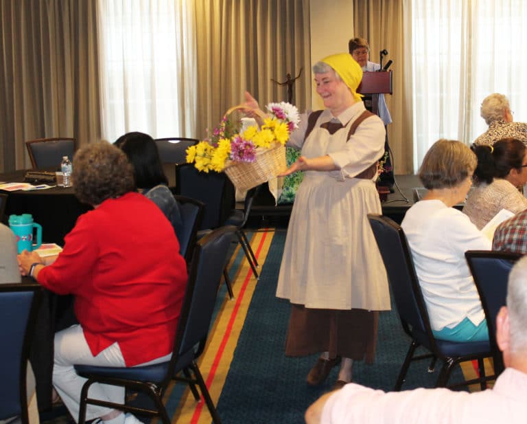Saint Angela Merici (Sister Pam Mueller) brought seeds to plant to open the Convocation and returned during the closing prayer ritual with the flowers that had bloomed.