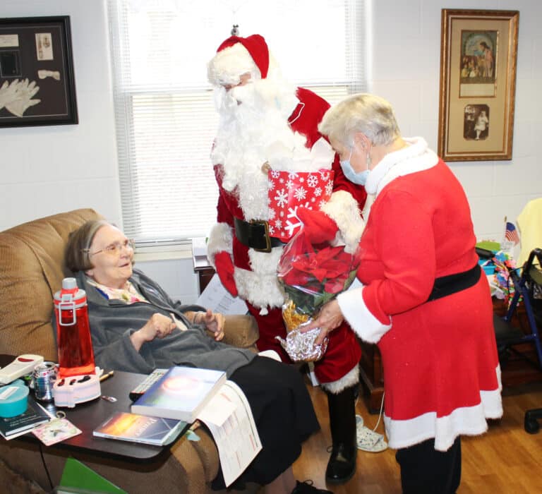 Sister Lois Lindle perks up when she sees Santa and Mrs. Claus bearing gifts.