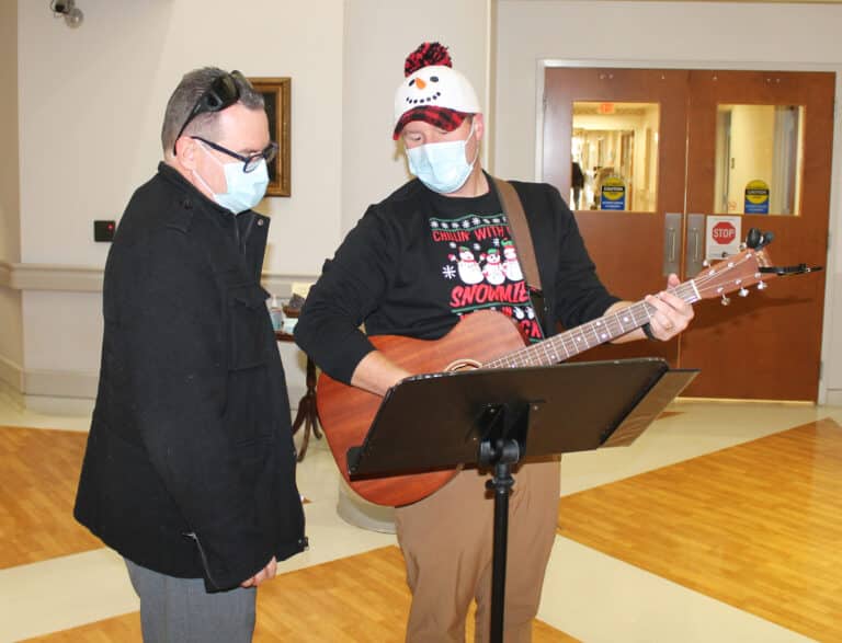 Deacon Chris Gutierrez, left, director of Hispanic/Latino Ministry, and Charlie Hardesty, director of Youth and Young Adult Ministry, practice “Feliz Navidad” before the caroling began. Deacon Chris Gutierrez, left, director of Hispanic/Latino Ministry, and Charlie Hardesty, director of Youth and Young Adult Ministry, practice “Feliz Navidad” before the caroling began.