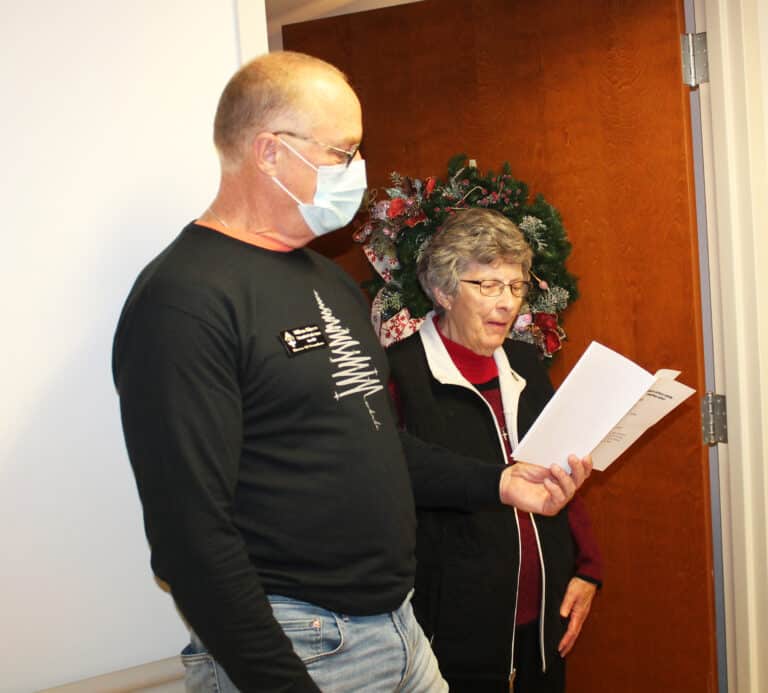 Bill Blincoe, director of Project and Risk Management, holds the song lyrics for Sister Margaret Ann Aull to sing along with a carol.