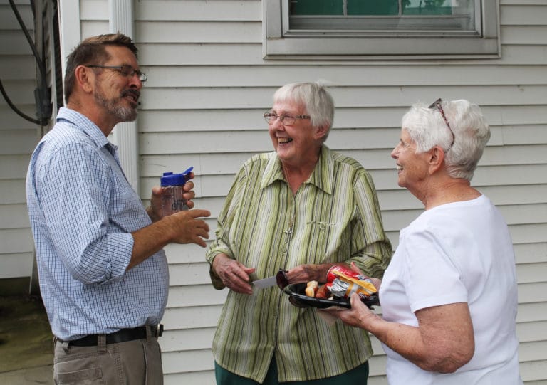 Ursuline Sister Grace Simpson, center, smiles as she visits with Mike Handy and volunteer Judy Cunnigan. Handy was an employee at Sister Visitor when Sister Grace began ministering there in 1984. She retired in 2014.