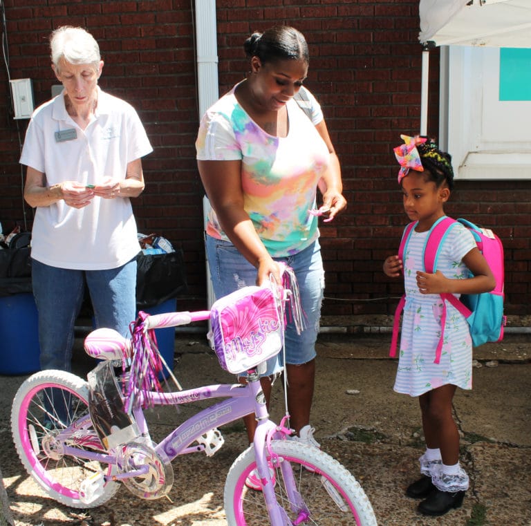 Journey looks over her new bicycle with her mother and Ursuline Sister Maureen O’Neill. Journey’s previous bicycle was stolen recently, so “this is a blessing,” her mother said.