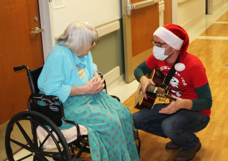 Sister Sheila Anne Smith asks Danny May to play a few chords on his guitar. Sister Sheila Anne Smith asks Danny May to play a few chords on his guitar.