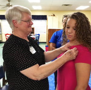 Ursuline Sister Suzanne Sims, who founded the Whitesville Y-DOSA chapter, pins Taylor Pedley.