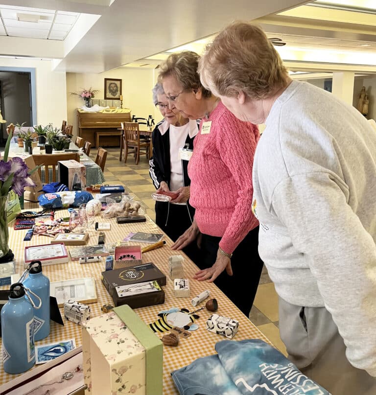 From the far end, Sister Ann Patrice Cecil, Sister Susan Mary Mudd and Sister Helena Fischer peruse the gift table for winning bingo.