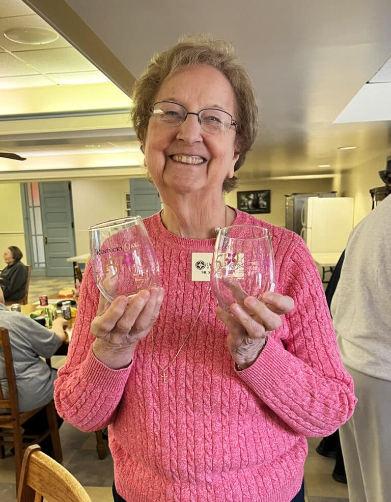 Sister Susan Mary Mudd sports two Kentucky Oaks glasses she won as a prize.