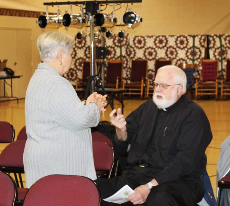 Ursuline Associates Elaine Wood and Father Ray Goetz talk before the program began.