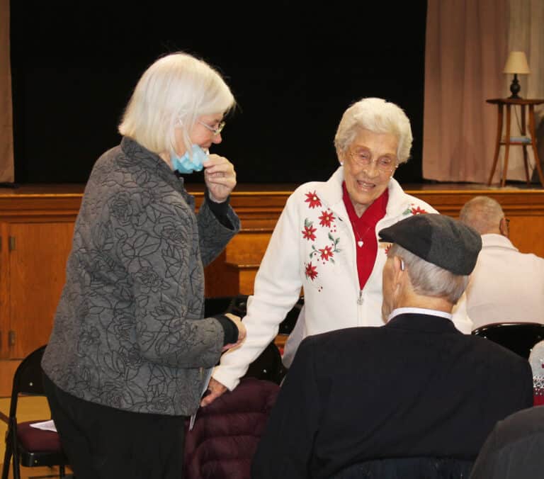 Sister Nancy Liddy, left, and Sister Elaine Burke talk with Sister Elaine’s brother.