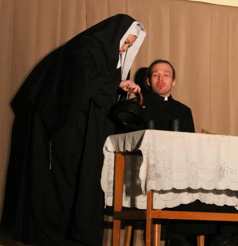 Sister Johanna Froeba, portrayed by Mary-Katherine Maddox, pours one of her tonics for Father Paul Volk, played by Edward Wilson, during the play “Legacy Sisters.”