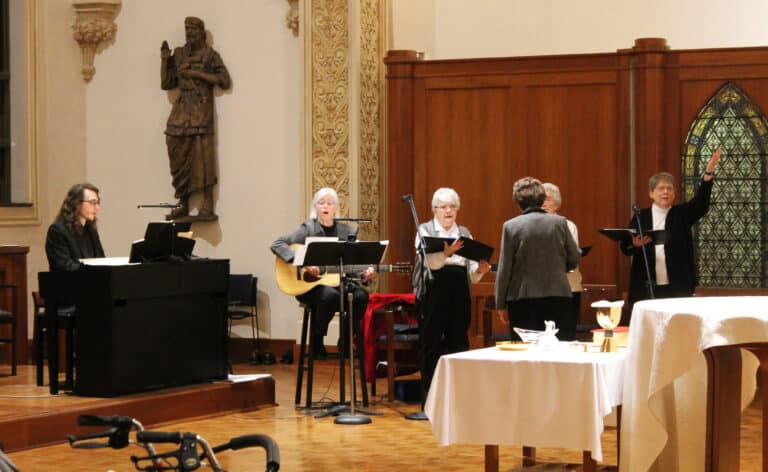Nolan Snyder, director of Music at St. Meinrad Seminary in Indiana, plays the piano as a scola of Sisters sings during Mass. From left are Sister Nancy Liddy, Sister Cecelia Joseph Olinger, Sister Mary Henning (leading the singers), Sister Elaine Burke and Sister Amelia Stenger.