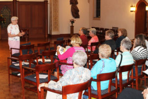 Sister George Mary Hagan, left, gives a brief history of how the Ursuline Sisters came to Maple Mount, as the visitors gathered in the chapel.