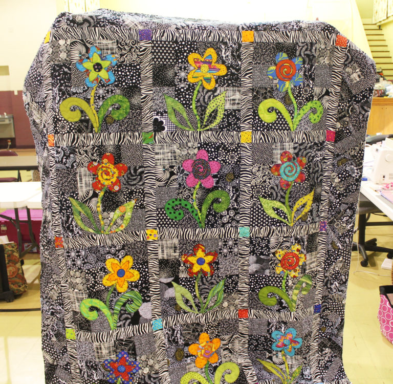 Beth Branstetter is hidden behind this quilt she made, which just needed the binding added.