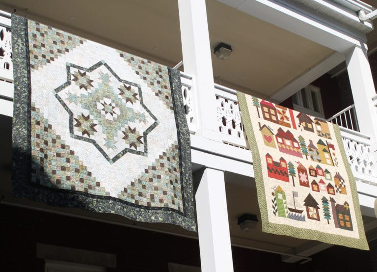 Each year, participants hang completed quilts on the railing of the Retreat Center courtyard for everyone to enjoy.