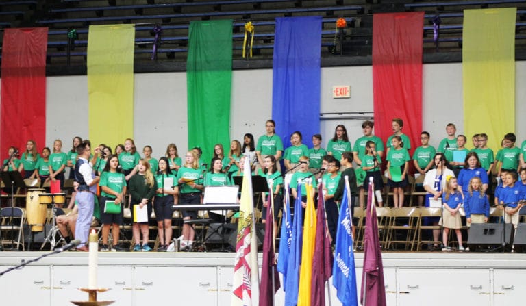 Students from the Daviess County Catholic schools lead the singing, under the direction of Jacob Hein, left.