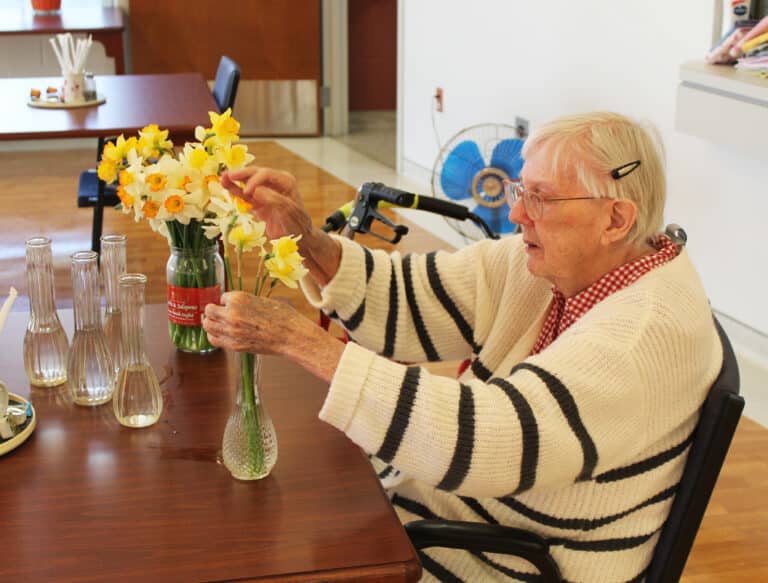 Sister Grace Simpson arranges jonquils and other flowers in vases to place on the tables in Saint Joseph Villa.