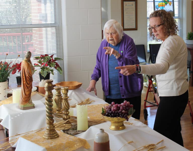 Sister Catherine Kaufman, left, gives Ashley Wilkerson a pointer about decorating the table.