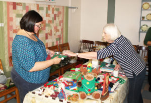 Sister Stephany Nelson, left, holds a Christmas item as Lucy Hines decides on a price during the set-up.