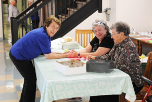 Sister Elaine Burke, left, visits with sales helper Associate Jody Ziegler, center, and Sister Ruth Mattingly. They were working the checkout desk.