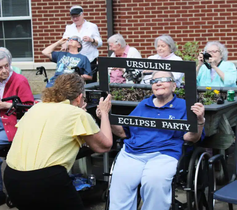 Sister Kathleen Dueber poses with the Eclipse Party frame as Ashley Wilkerson, who organized the party, takes her picture. Sister Kathleen Dueber poses with the Eclipse Party frame as Ashley Wilkerson, who organized the party, takes her picture.