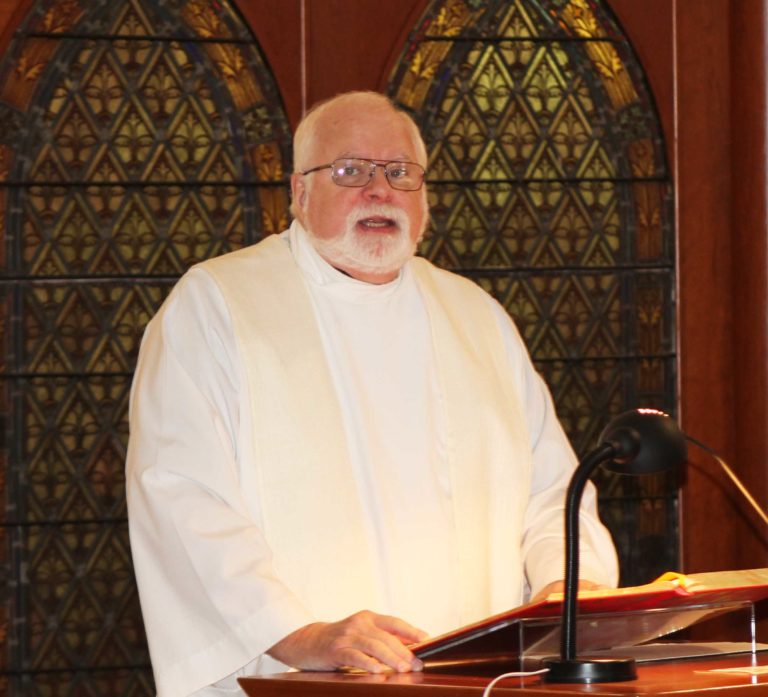 Father Ray Goetz, chaplain at Mount Saint Joseph, reads from the Gospel of John.