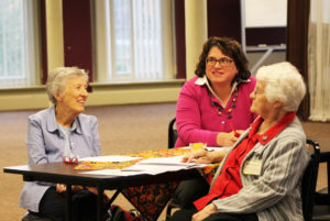 Ursuline Sisters Marietta Wethington, left, and Mary Matthias Ward, right, discuss a Merton question with Lisa Gulino.