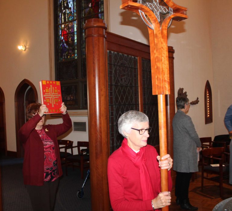 Carolyn Drury McCarty, A71, carries the processional cross, as Maggie Jenkins Beville, A65, carries in the lectionary.