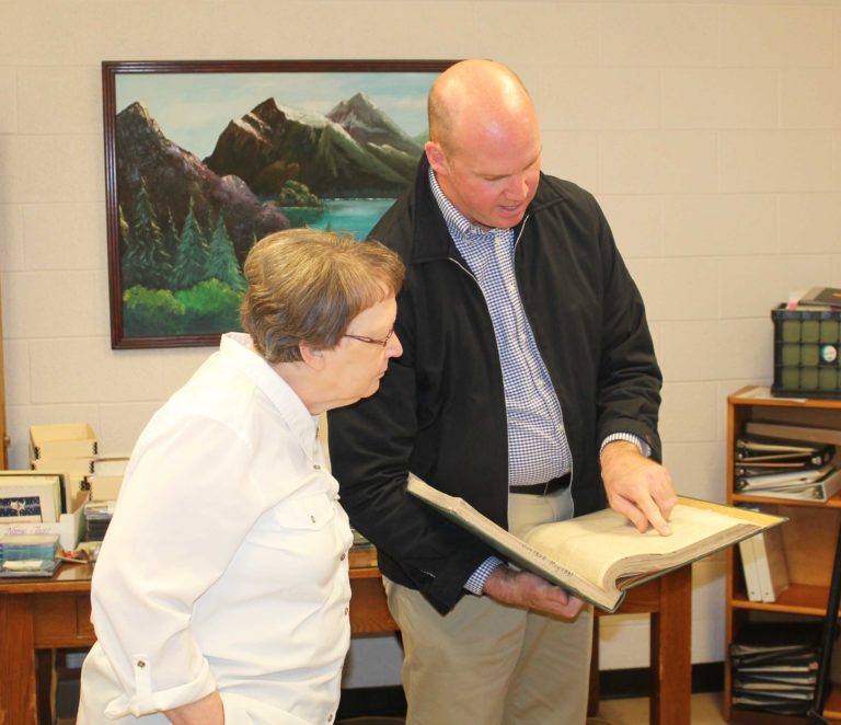 Tim Tomes reads through a copy of The Guardian from 1858-1861 while Sister Amelia Stenger looks on.