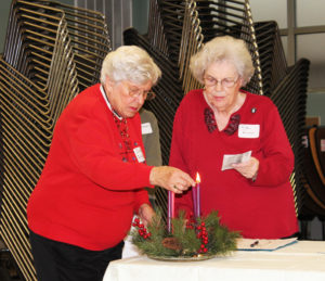 Ursuline Associate Irene Quigley lights an Advent candle as Ursuline Associate Rita Wilkus reads a prayer to open the Advent Day of Reflection.