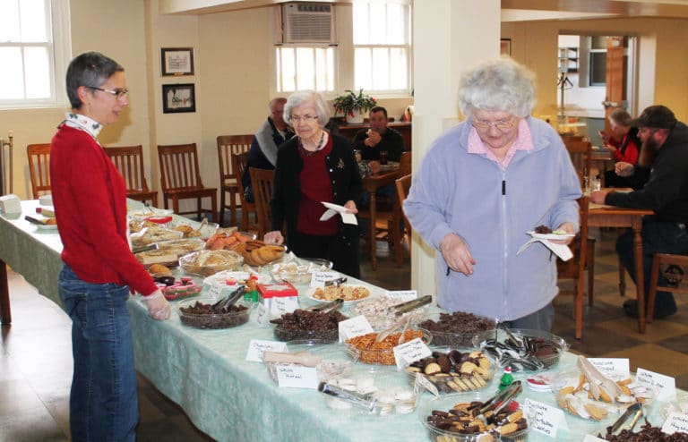 Sister Francis Louise Johnson, right, and Sister Mary Diane Taylor do the impossible and choose just a few items from the smorgasbord, as Maryann Joyce looks on.