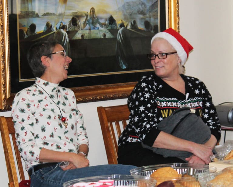 Maryann Joyce and Mary Lykins, both Center employees, share a laugh during a lull in the line. Joyce will take over as director of the Center on Jan. 1.