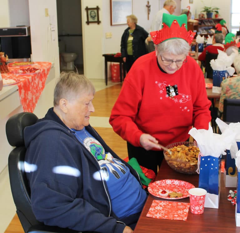 Associate Lois Bell serves some Chex mix to Sister Dee Long.