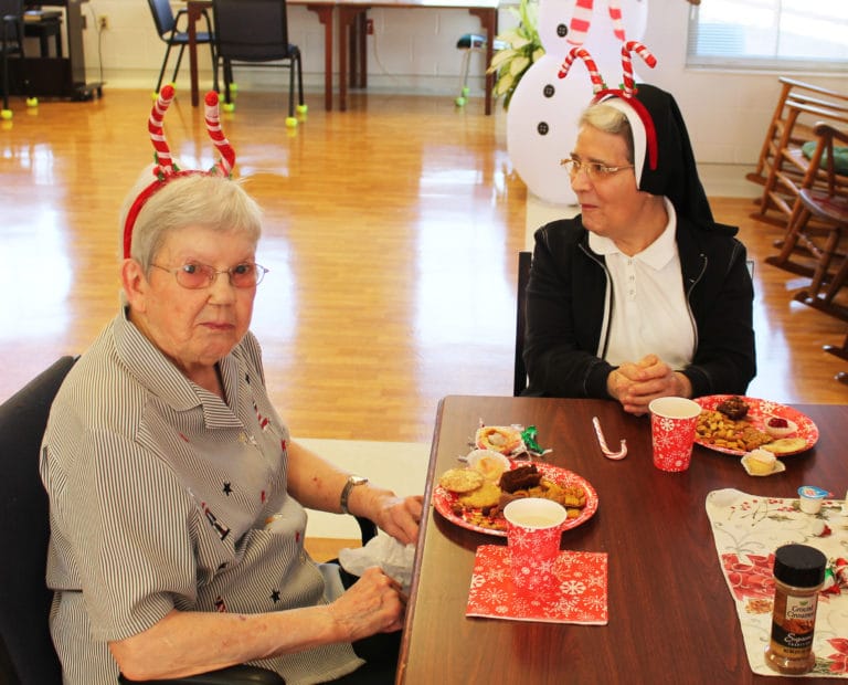 Sister Marie Montgomery, left, and Sister Rose Karen Johnson enjoy their snacks while patiently awaiting Santa.